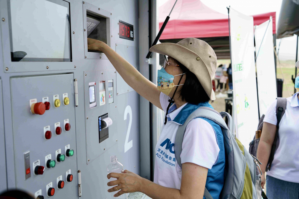 志工們將拾起的寶特瓶投入「好歸塑專車」，讓廢棄塑料空瓶可以直接粉碎、縮小體積，未來將可再製成購物袋、寶特衣、悠遊卡等生活用品